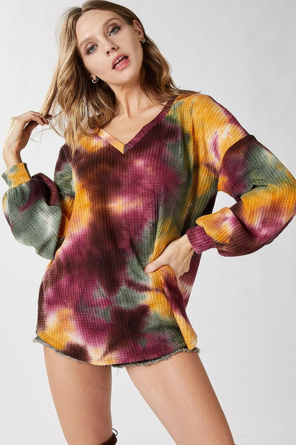 Detailed view of the v-neckline on this artistic maroon and olive green 70s retro style top.