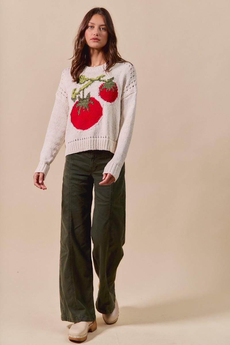 Close-up of the soft cotton blend material and intricate knit pattern on this red and cream jumper