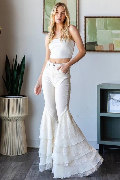 Festival fashion look featuring off-white tiered lace bell bottoms paired with a Western cowgirl aesthetic