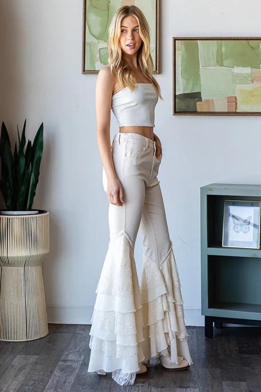 Side profile of Cottagecore white ruffle flare jeans showing the stretch cotton fit and voluminous tiered hem