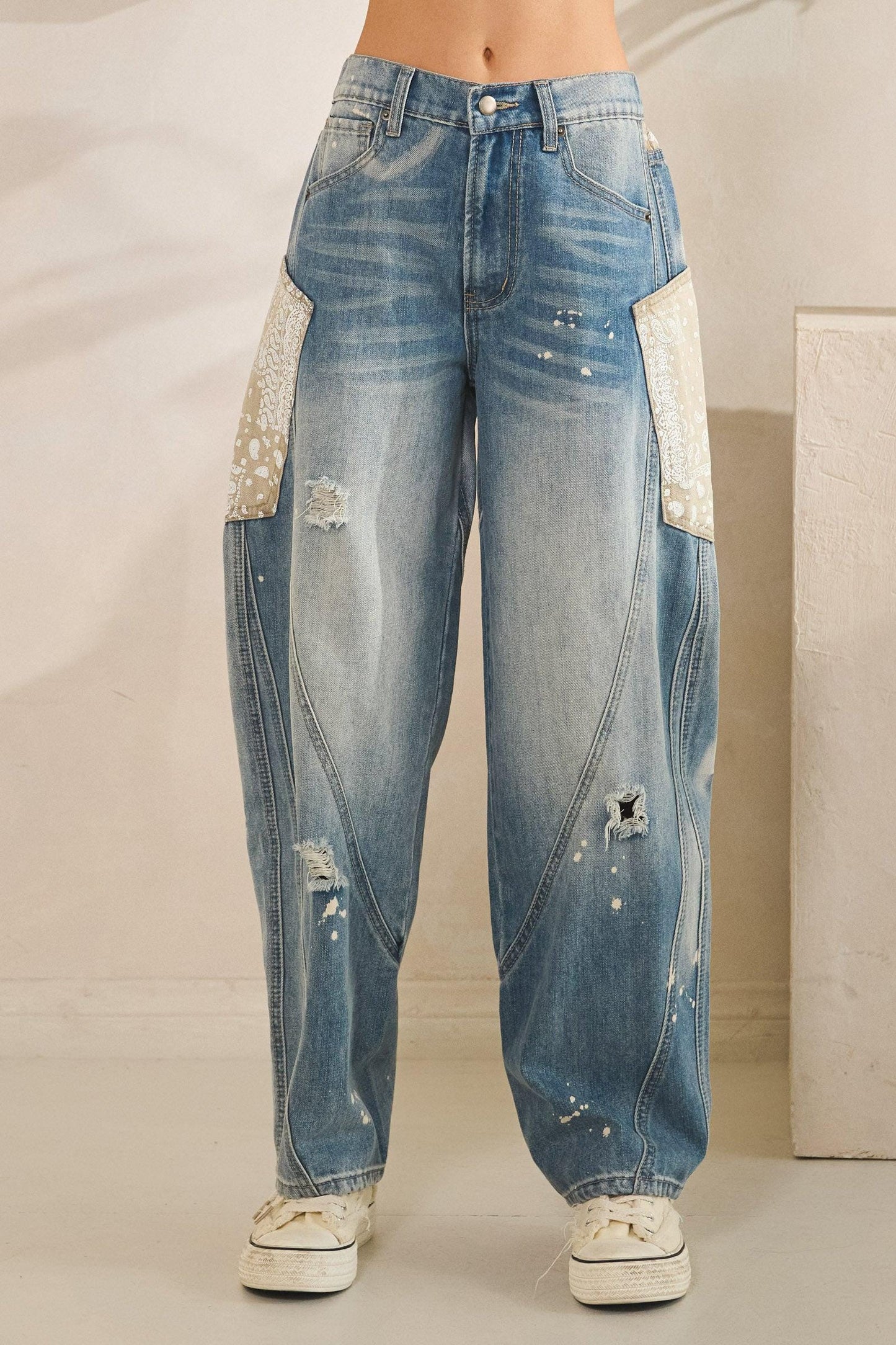 Partial elastic waistband and button closure on high-waisted distressed denim for a comfortable fit