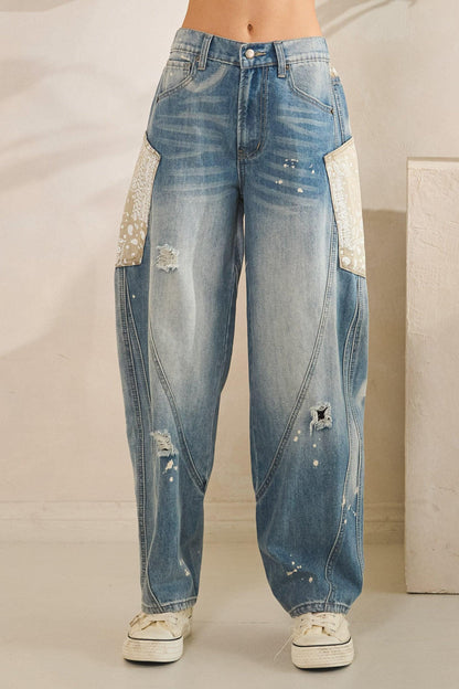 Partial elastic waistband and button closure on high-waisted distressed denim for a comfortable fit