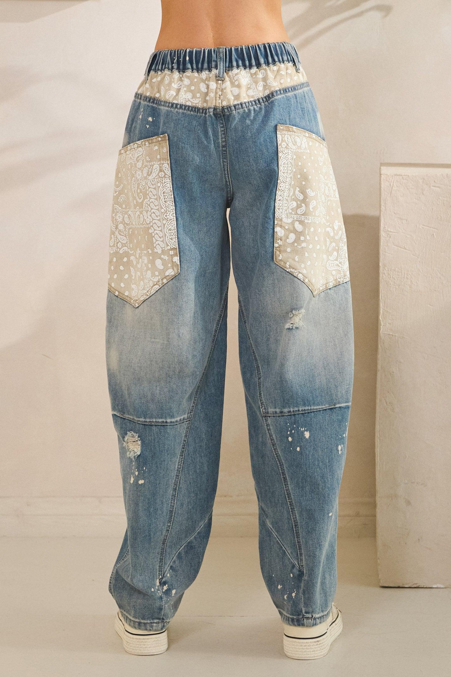 Flat lay of light blue distressed jeans with floral patchwork, perfect for a soft girl or Y2K outfit