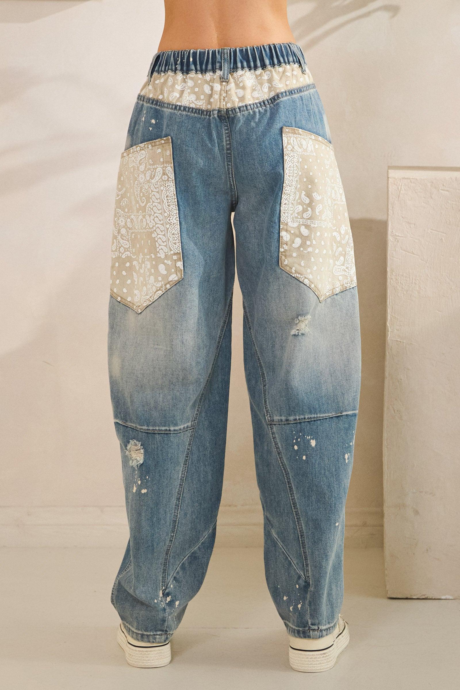 Flat lay of light blue distressed jeans with floral patchwork, perfect for a soft girl or Y2K outfit