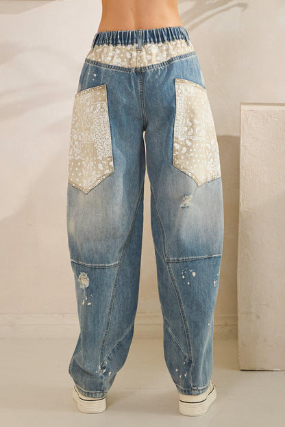 Flat lay of light blue distressed jeans with floral patchwork, perfect for a soft girl or Y2K outfit