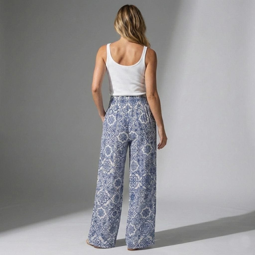 Rear view of flowy tall linen trousers featuring an Amalfi Coast inspired blue tile pattern
