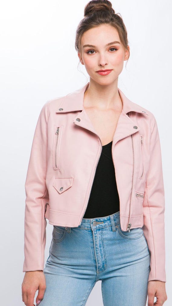 Close-up texture of blush pink faux leather on Barbiecore biker jacket