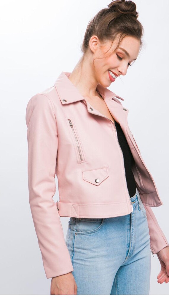 Lifestyle shot of woman wearing a trendy pink faux leather jacket, streetwear style