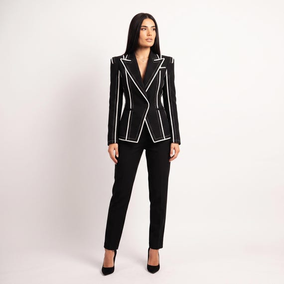 Lifestyle shot: Woman wearing statement black blazer for power dressing