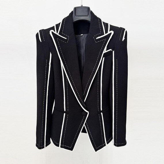 Side profile of edgy office jacket, black with white contrast details