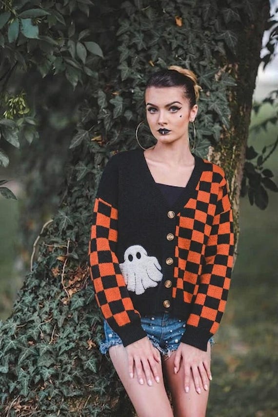Back view of Whimsigoth Halloween cardigan showing the split design and cozy slouchy fit in orange and black