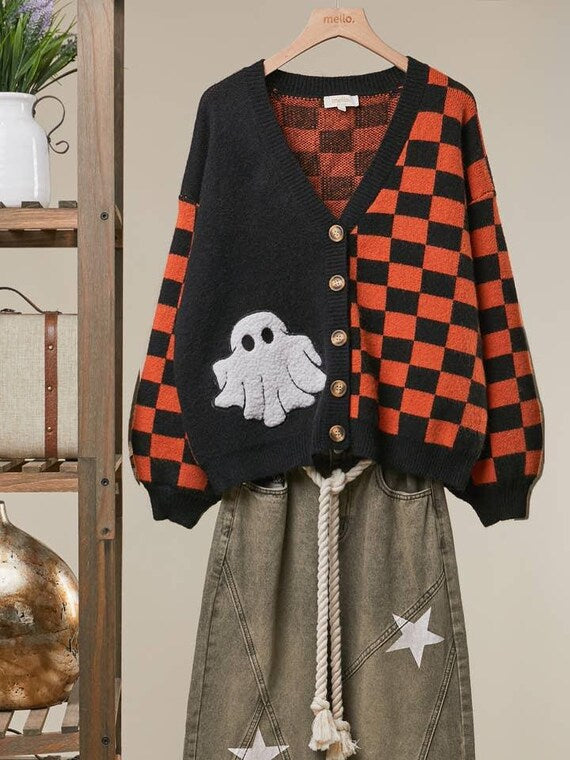 Close-up of the soft white chenille ghost patch on the black knit panel of the spooky autumn cardigan