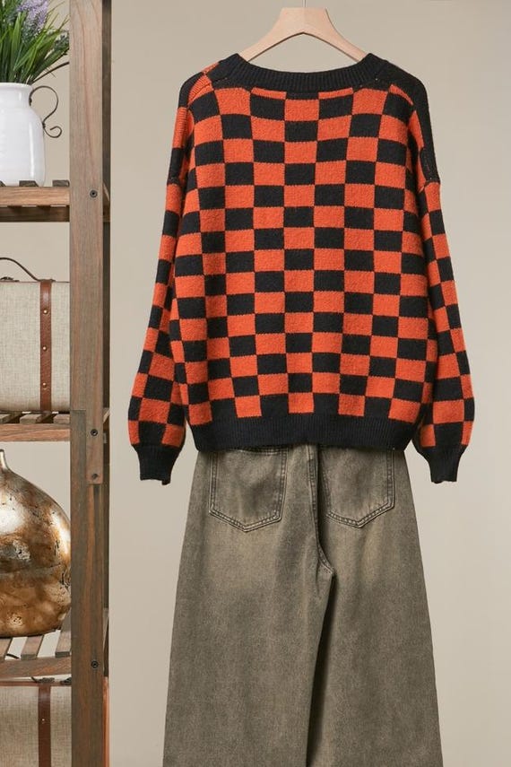Detail of the durable button-front closure on the orange and black checkered knit Halloween sweater