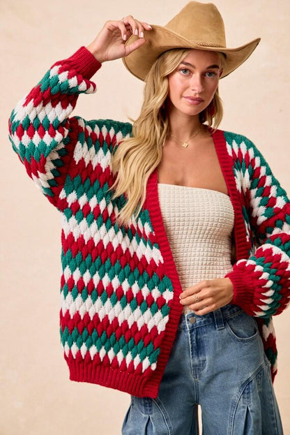 Close-up of the chunky knit polyester fabric on a cozy red and green Christmas colors cardigan