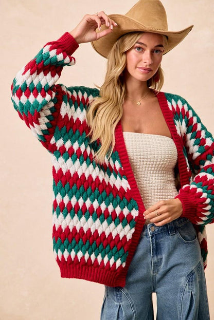 Angled shot of a relaxed-fit women's holiday cardigan in a festive red, white, and green diamond design