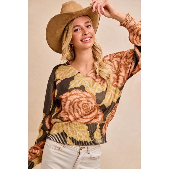 Women's dark olive floral knit V-neck sweater with balloon sleeves, showing rustic peach and golden yellow blooms.