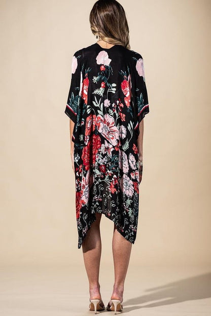 Overhead view of a flowing black floral print wrap cardigan, 38-inch length, showcasing oversized botanical pattern.