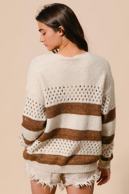 Back view of a relaxed-fit cream knit sweater featuring brown stripes and perforated knit details in a boho casual style.