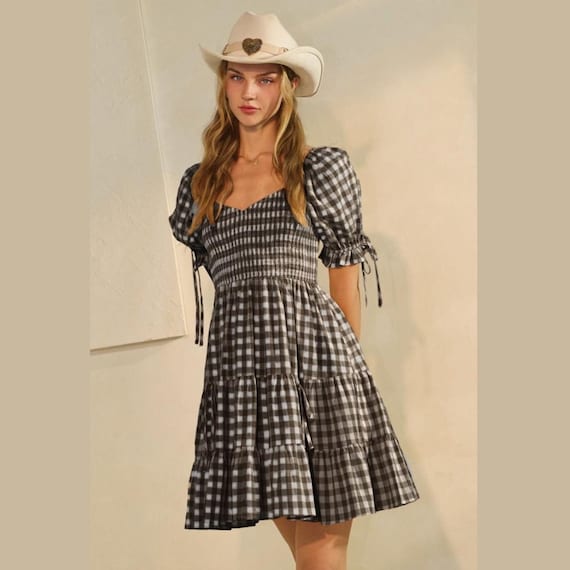 Women's coastal cowgirl gingham puff sleeve mini dress with a shirred bodice, tiered skirt, and cowboy hat.