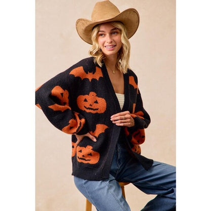 Women's cozy Whimsigoth black open-front knit cardigan with bold orange pumpkin and bat print, relaxed fit, generous sleeves.