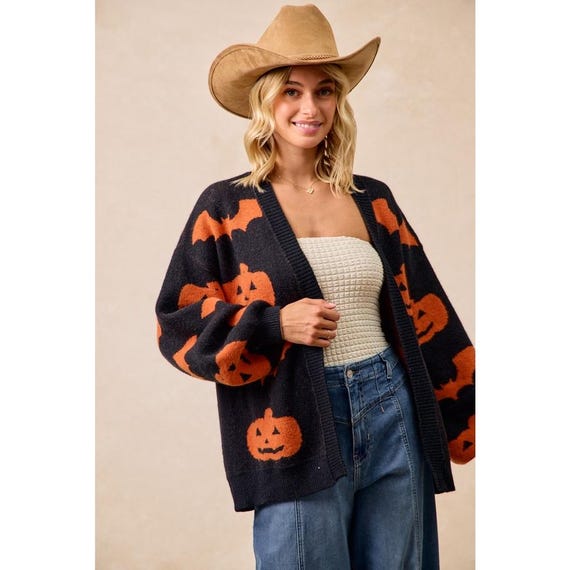 Cozy Whimsigoth black knit open-front cardigan with orange pumpkin and bat print, featuring a relaxed fit and extended sleeves.