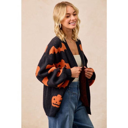 Detailed close-up of the unique dark botanical pumpkin and bat pattern on this spooky knit cardigan.