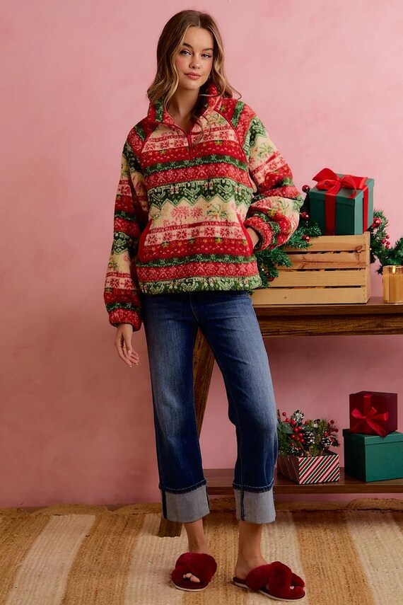 Women's cozy red and green Fair Isle sherpa quarter-zip pullover styled with cuffed blue jeans.