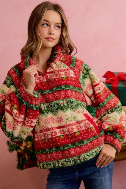 Woman wearing a festive red, green, and cream Fair Isle cottagecore sherpa quarter-zip pullover.