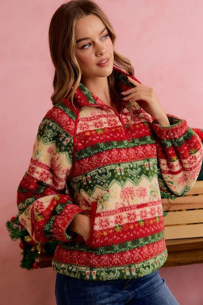 Model sitting by a fireplace wearing holiday cottagecore sweater with festive Fair Isle design.