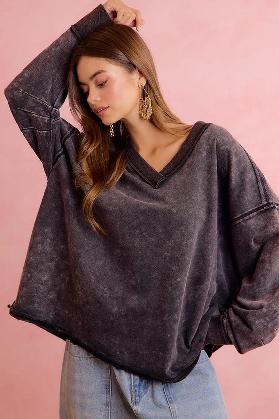 Women's oversized charcoal mineral wash terry cloth sweatshirt with raw edge seams and a deep V-neck.