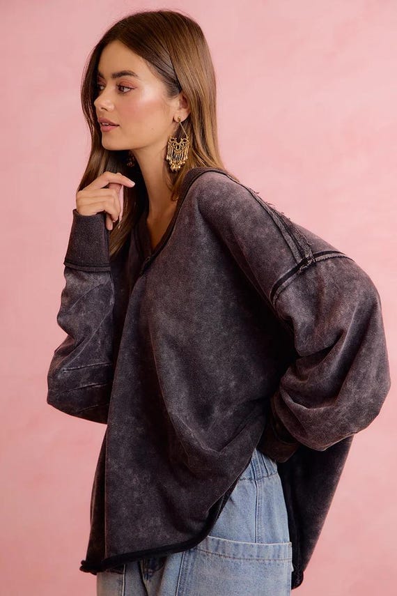A charcoal mineral wash terry cloth sweatshirt with oversized fit, dropped shoulders, and raw seam details.