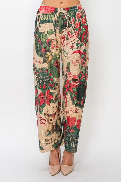 Close-up detail of retro Christmas print on cozy wide leg pants, showing Santas and poinsettias