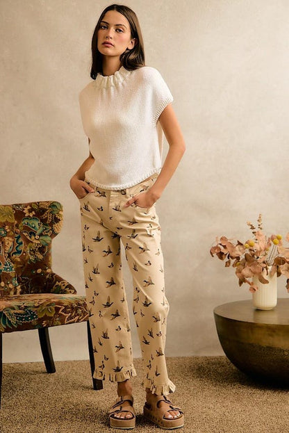 Cream cottagecore wide leg pants with mallard duck print and a ruffle hem, paired with a white knit top.