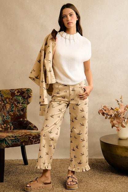 Cream wide leg cotton denim pants with a mallard duck print and a ruffle hem in a cottagecore style.