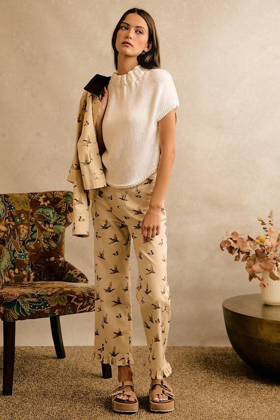 Cream wide-leg cotton denim pants with mallard duck print, ruffle hem, styled for a playful Cottagecore aesthetic.