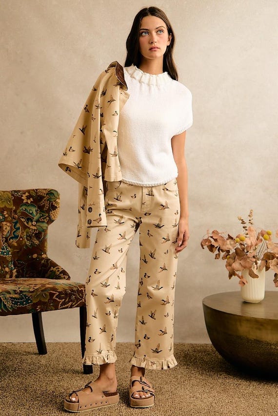 Woman in cream cotton denim wide-leg pants featuring mallard duck print and ruffle hem, styled for Cottagecore.